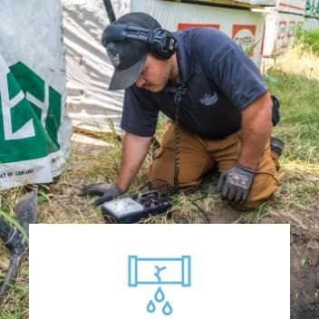 man on grass outside using a device to diagnose service problem