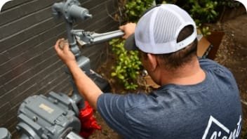 worker using wrench to tighten gas service pipes